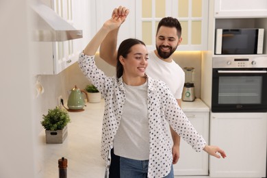 Happy lovely couple dancing together in kitchen
