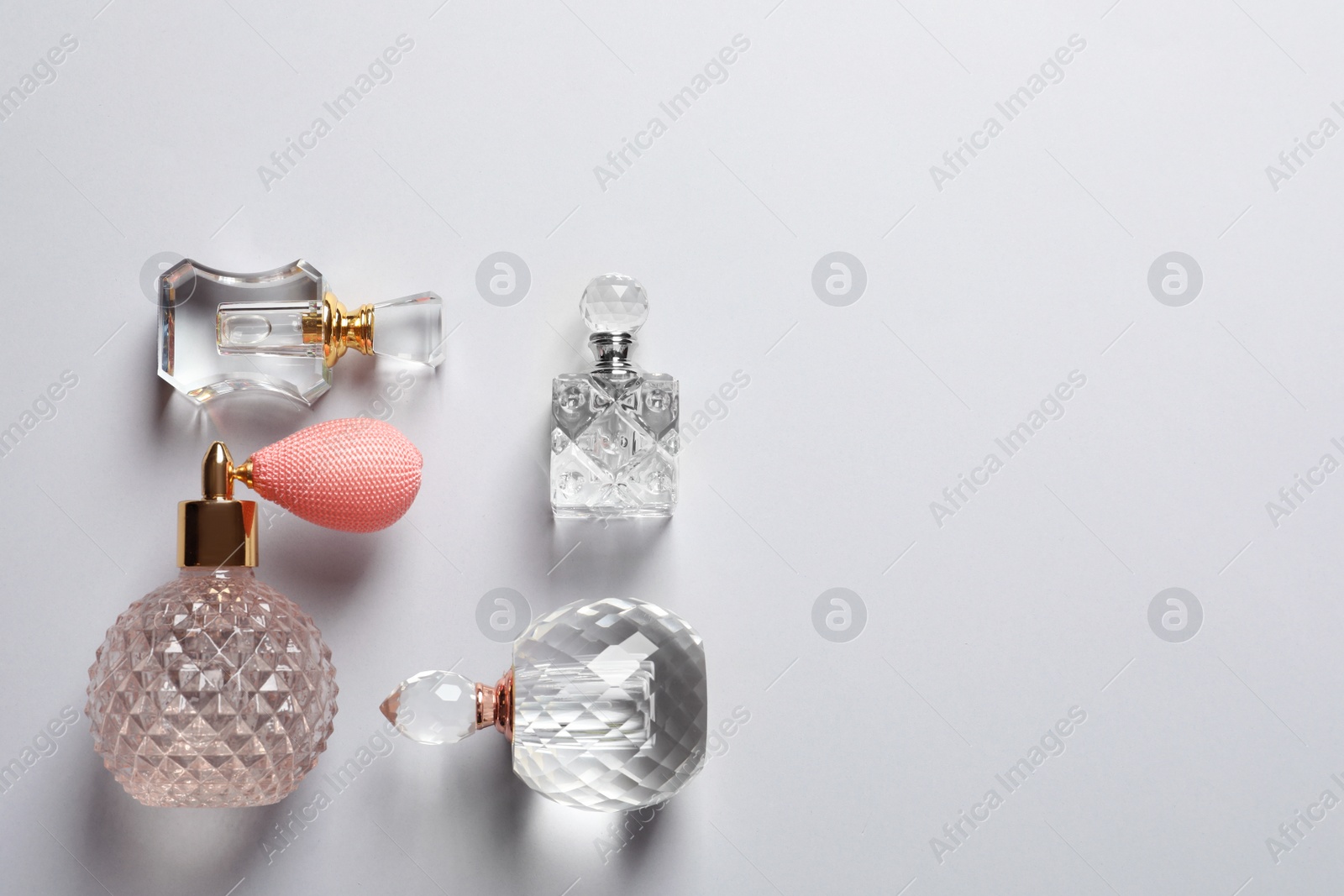 Photo of Flat lay composition with bottles of perfume and space for text on grey background