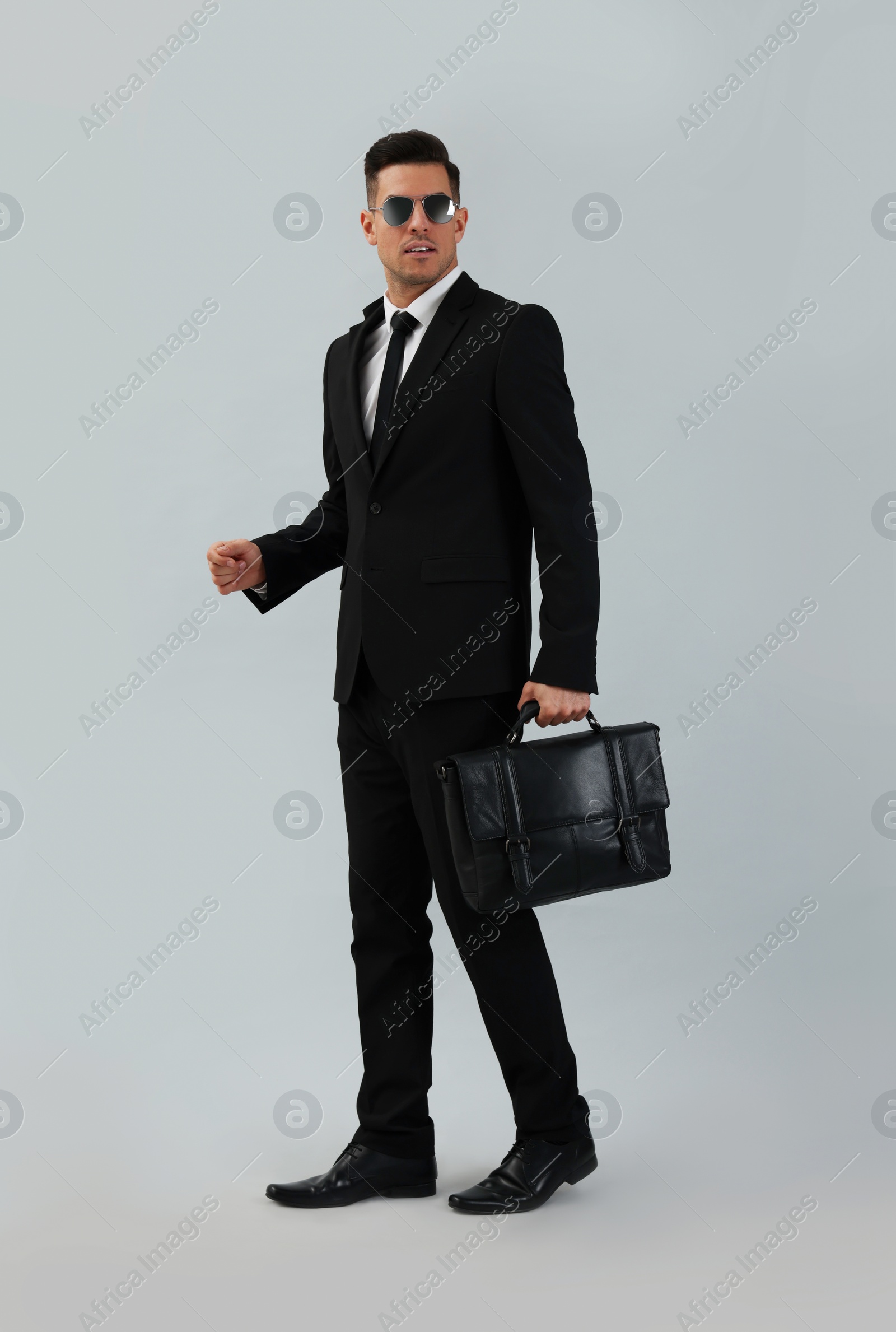 Photo of Businessman with stylish leather briefcase on light background