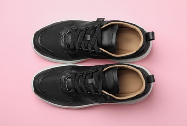 Photo of Pair of stylish shoes on pink background, top view