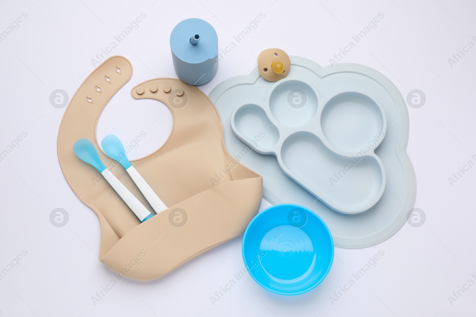 Photo of Composition with baby feeding accessories and bib on white background, top view