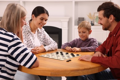 Family playing checkers at coffee table in room