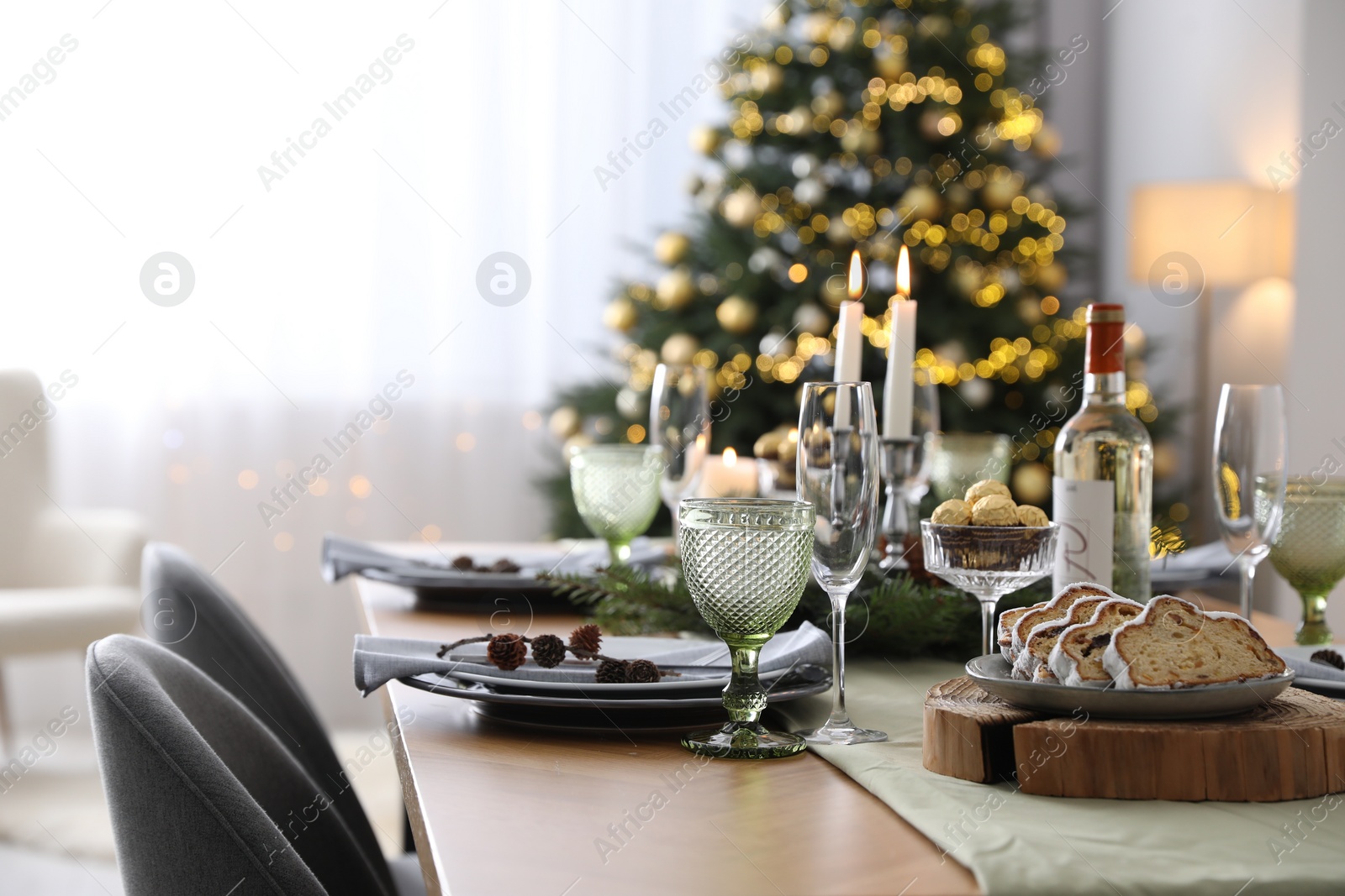 Photo of Christmas table setting with festive decor and dishware in room