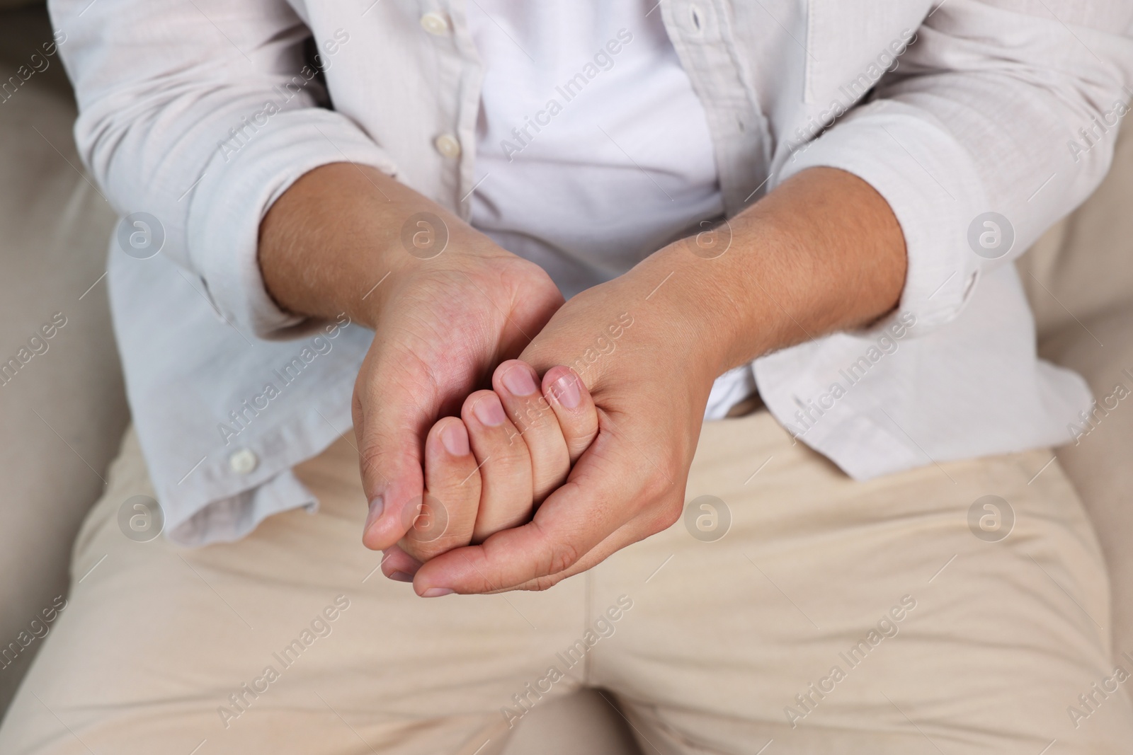 Photo of Man applying hand cream at home, closeup