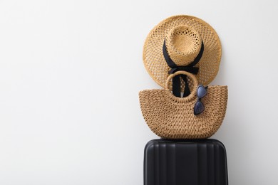 Photo of Suitcase and summer accessories on light background. Space for text
