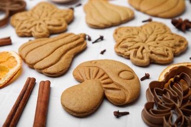 Photo of Different tasty cookies, spices and cutters on white table, closeup