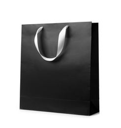 Photo of Paper shopping bag with ribbon handles on white background. Mockup for design