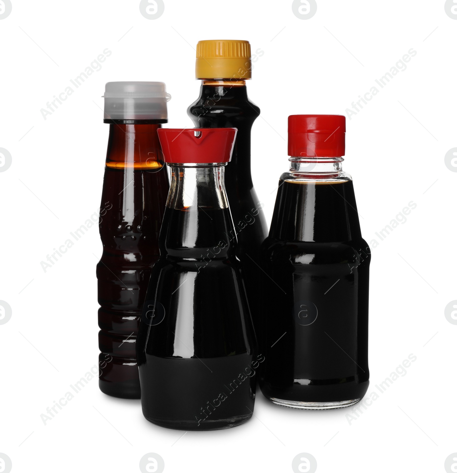 Photo of Bottles of tasty soy sauce isolated on white