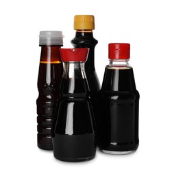 Photo of Bottles of tasty soy sauce isolated on white