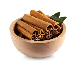 Cinnamon sticks and green leaves in bowl isolated on white