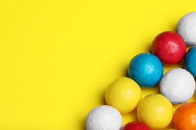 Many tasty bubble gums on yellow background, above view. Space for text
