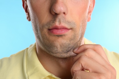 Young man with double chin on blue background, closeup