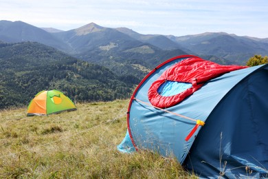 Photo of Red sleeping bag on camping tent in mountains