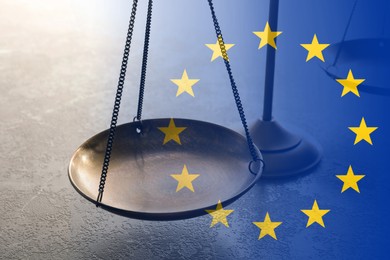 Image of Double exposure of European union flag and scales of justice on grey table, closeup