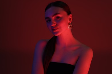 Photo of Portrait of beautiful young woman on color background in neon lights