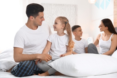 Photo of Happy young family together on large bed