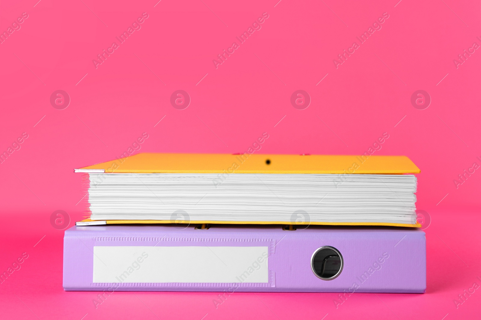 Photo of Bright hardcover office folders on pink background