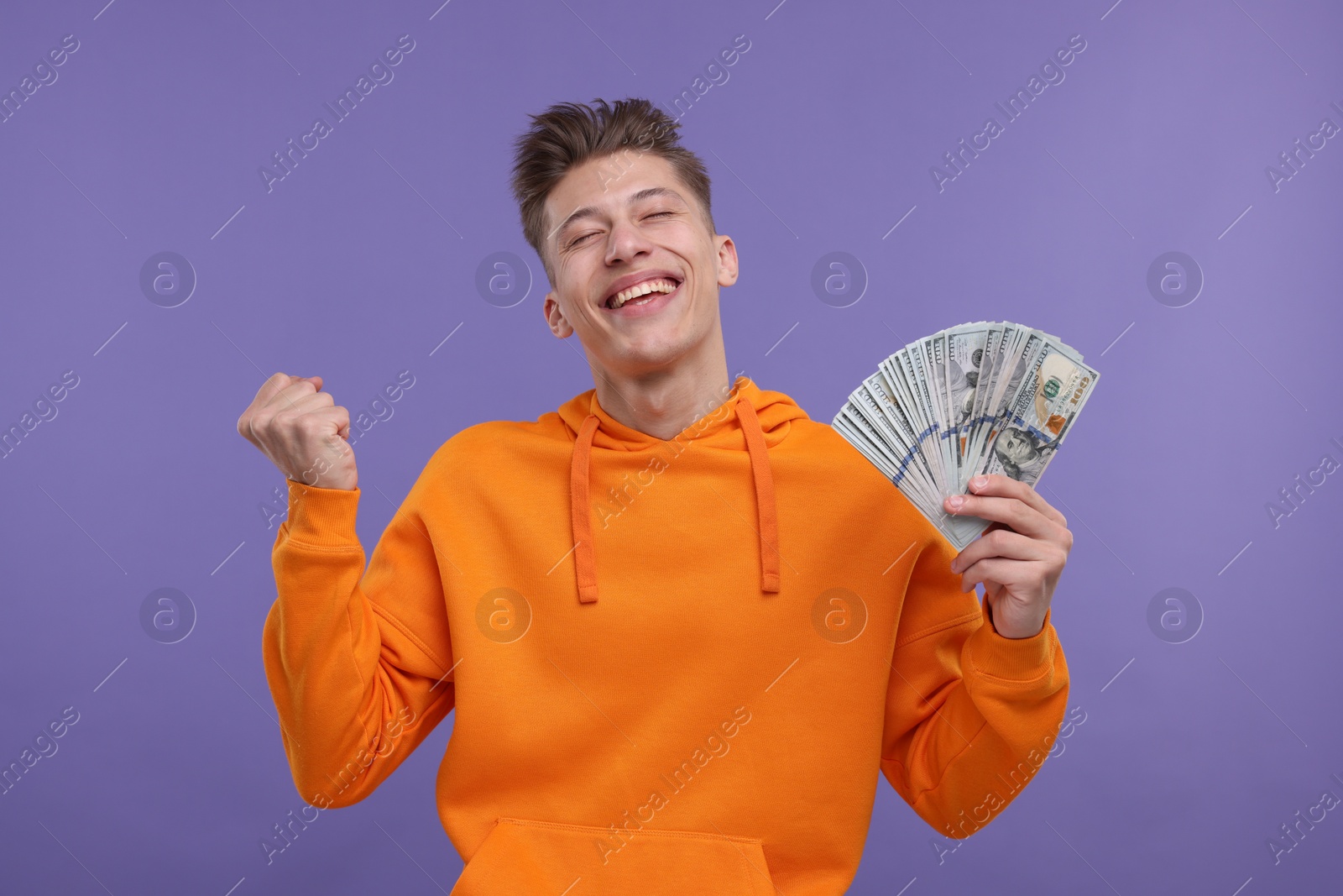 Photo of Happy man with money on purple background