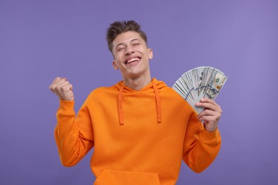 Happy man with money on purple background