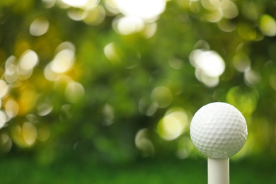 Golf ball on tee against blurred background
