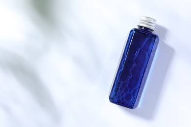 Photo of Bottle of cosmetic product on white background, top view. Space for text