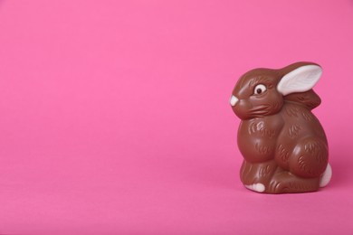 Photo of Chocolate bunny on pink background, space for text. Easter celebration