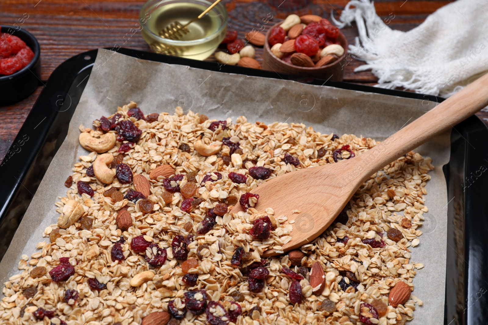 Photo of Tray with tasty granola, nuts and dry fruits on wooden table, closeup