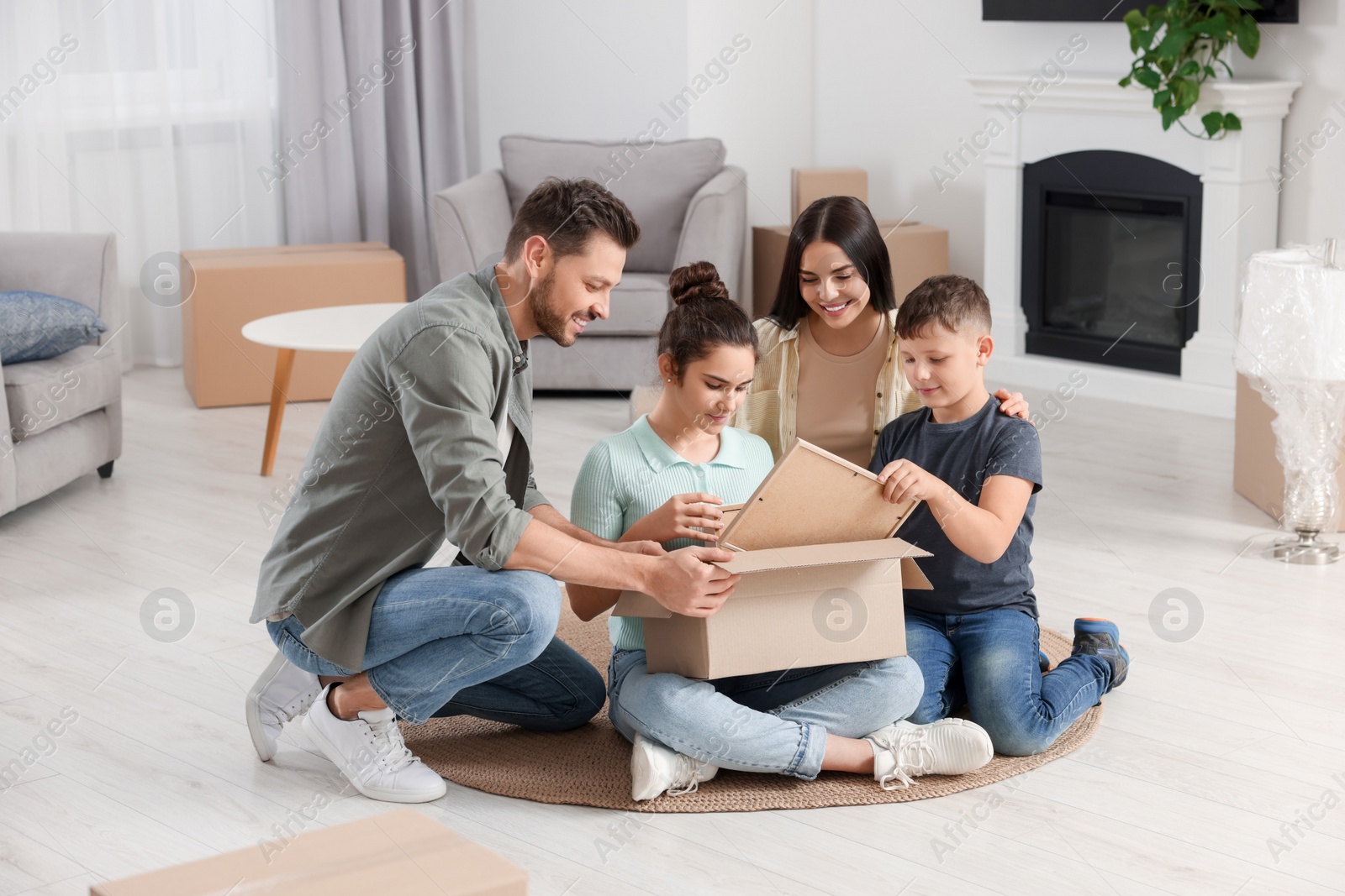 Photo of Happy family settling into new house and unpacking boxes on floor. Moving day