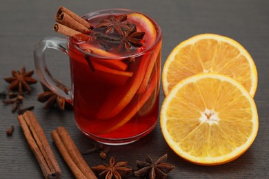 Aromatic punch drink and ingredients on wooden table, closeup