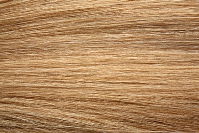 Texture of healthy blond hair as background, closeup