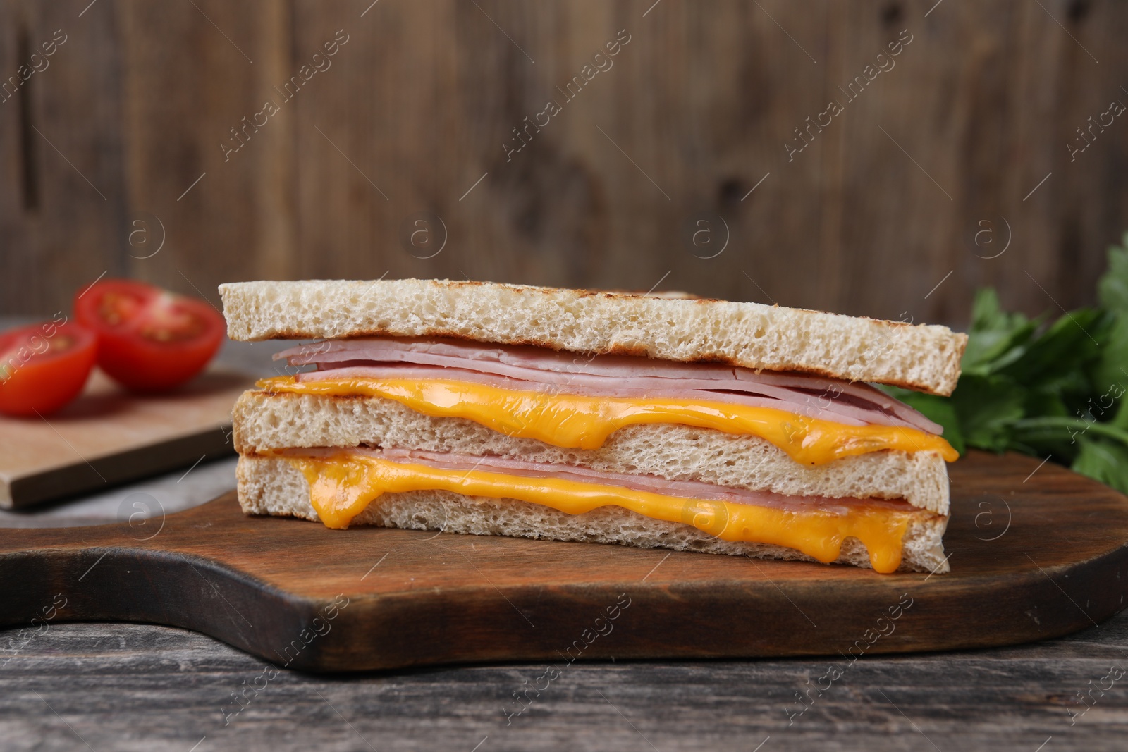 Delicious grilled sandwich with ham and cheese on wooden table, closeup Photo of Delicious grilled sandwich with ham and cheese on wooden table, closeup