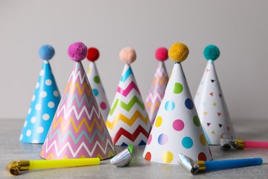 Photo of Birthday party hats and horns on grey table