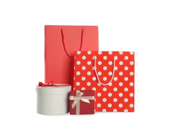 Photo of Paper shopping bags and gift boxes isolated on white