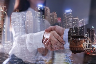 Image of Partnership, cooperation, collaboration. Double exposure of night cityscape and people shaking hands