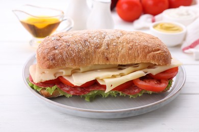 Delicious sandwich with cheese, salami, tomato on white wooden table, closeup