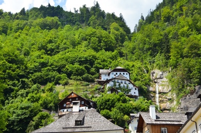 Picturesque view of town with beautiful buildings near mountain forest