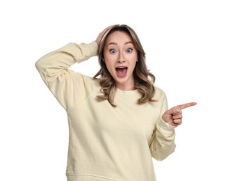 Portrait of surprised woman pointing at something on white background