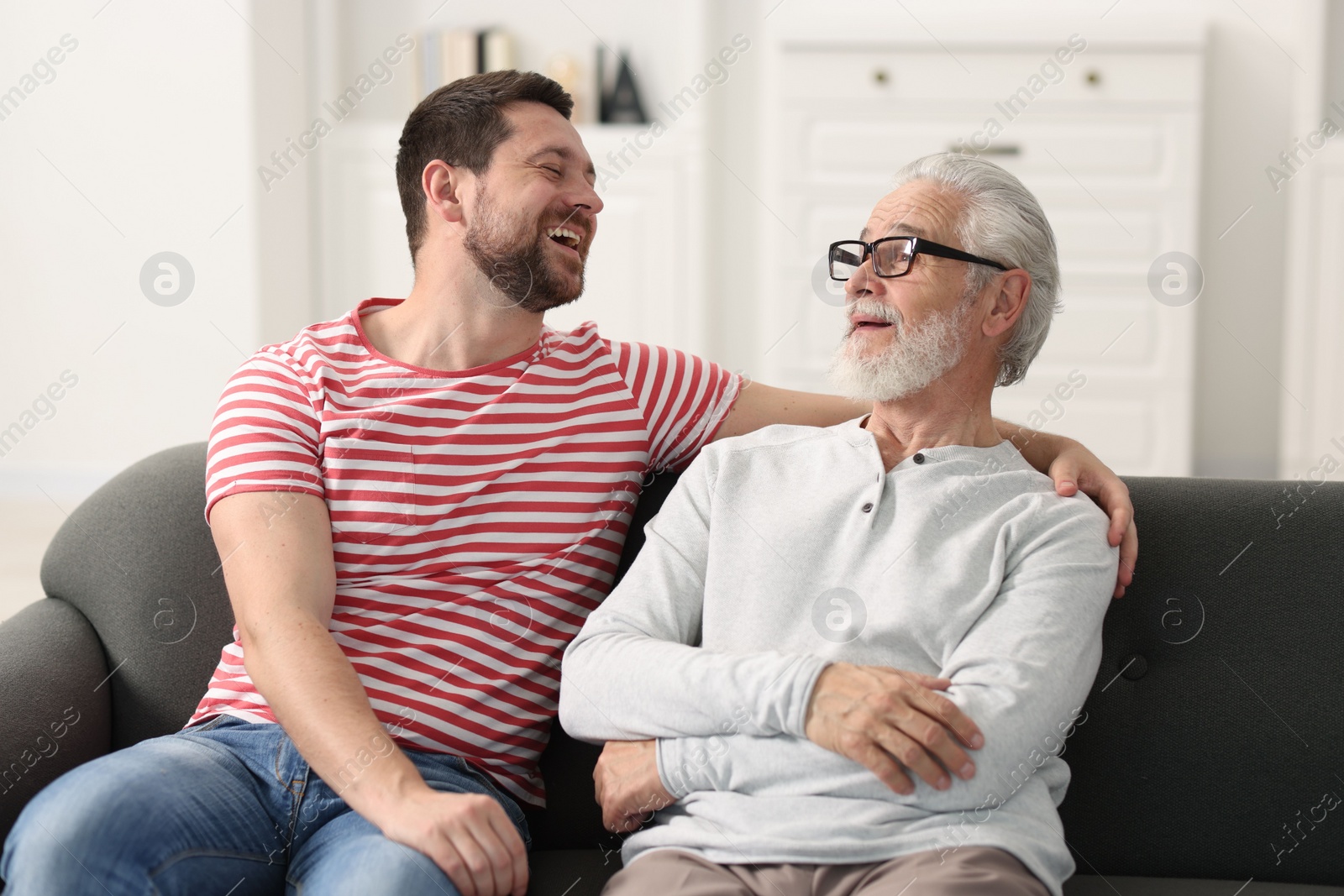 Photo of Happy son and his dad spending time together at home