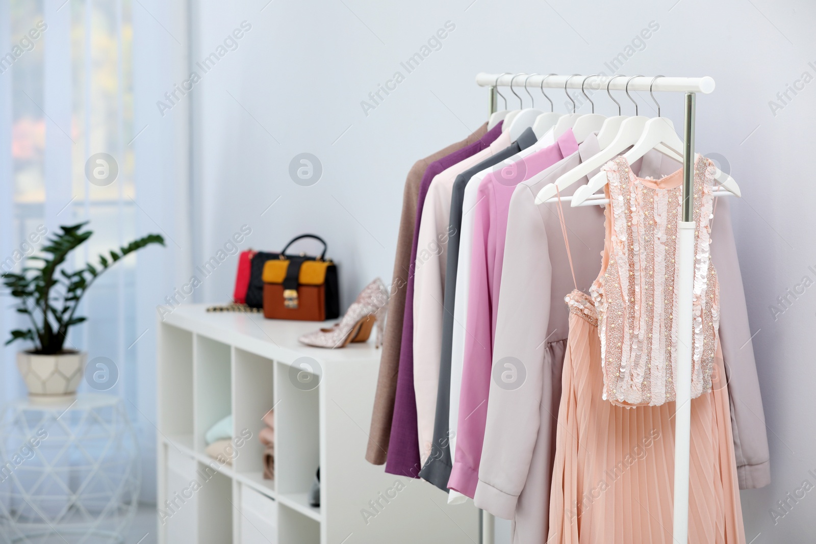 Photo of Rack with clothes in stylish dressing room interior. Space for text