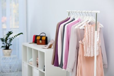 Photo of Rack with clothes in stylish dressing room interior. Space for text