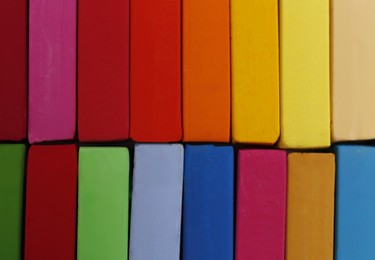 Photo of Set of colorful pastels as background, closeup. Drawing materials