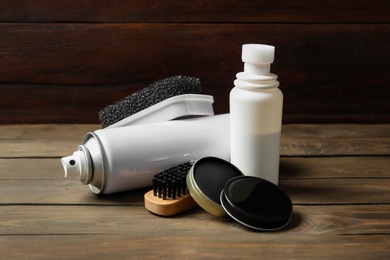 Photo of Composition with shoe care accessories on wooden table