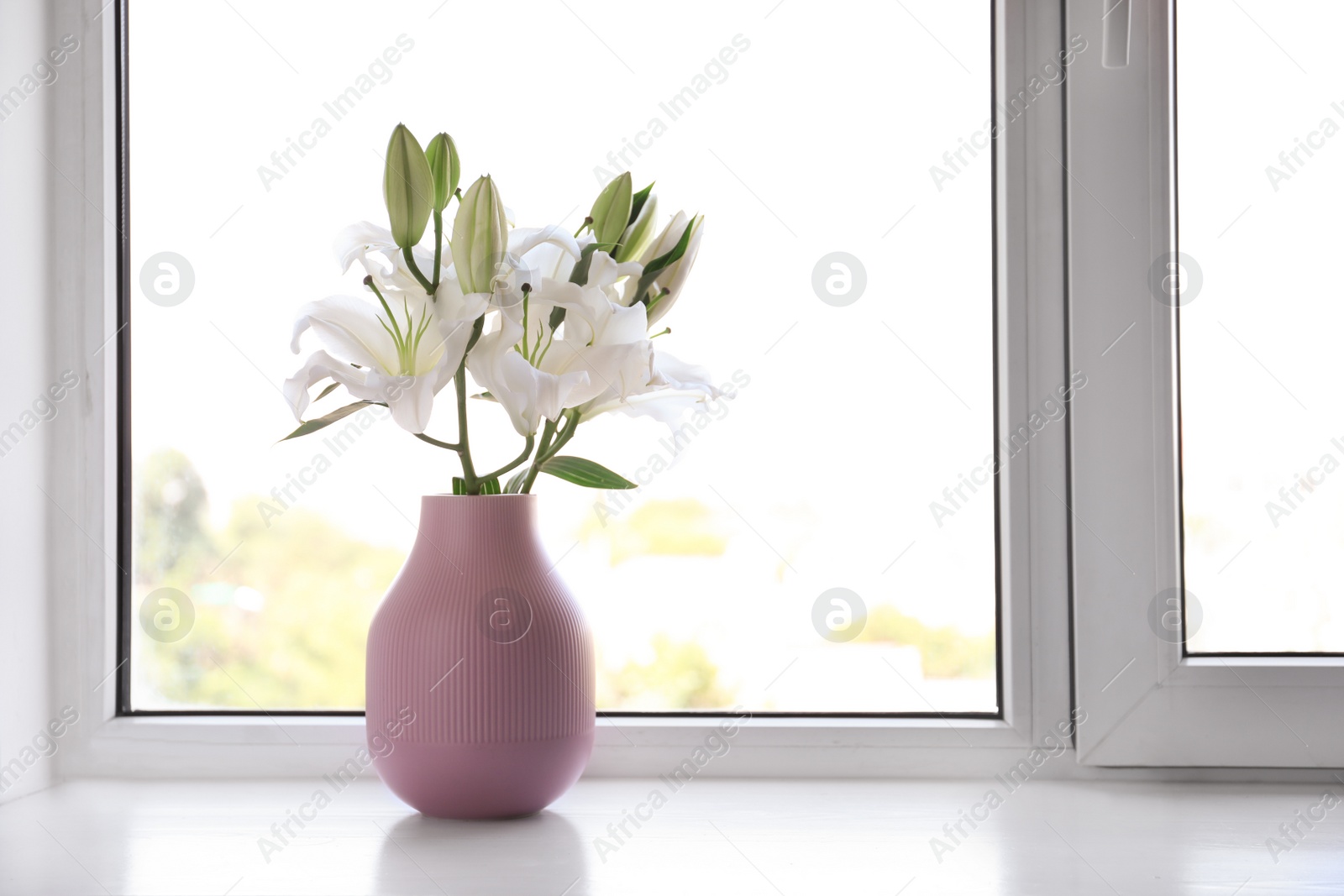 Photo of Vase of beautiful lilies on windowsill indoors, space for text