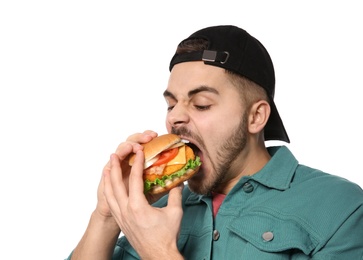 Handsome man eating tasty burger isolated on white