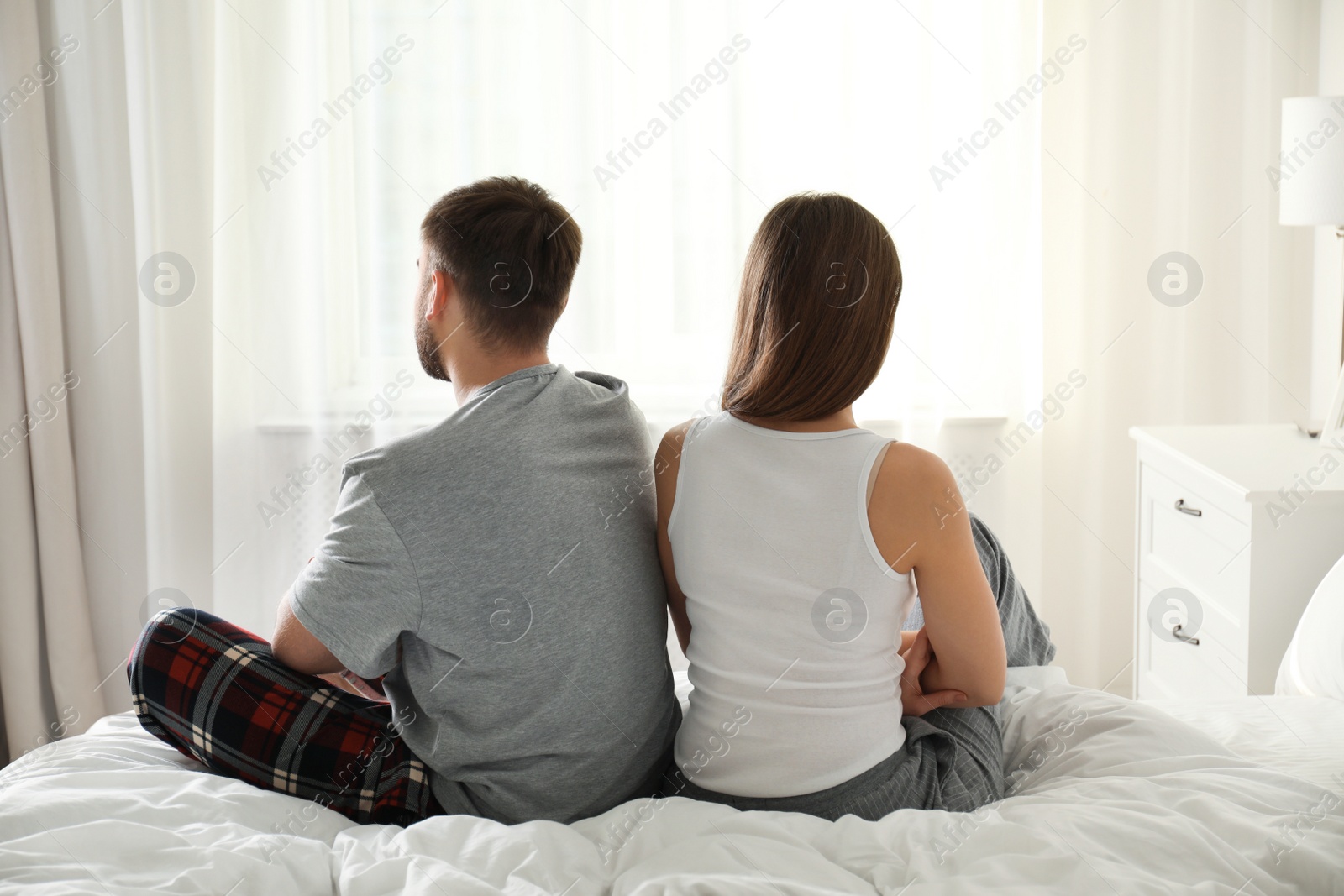 Photo of Unhappy couple with relationship problems after quarrel in bedroom