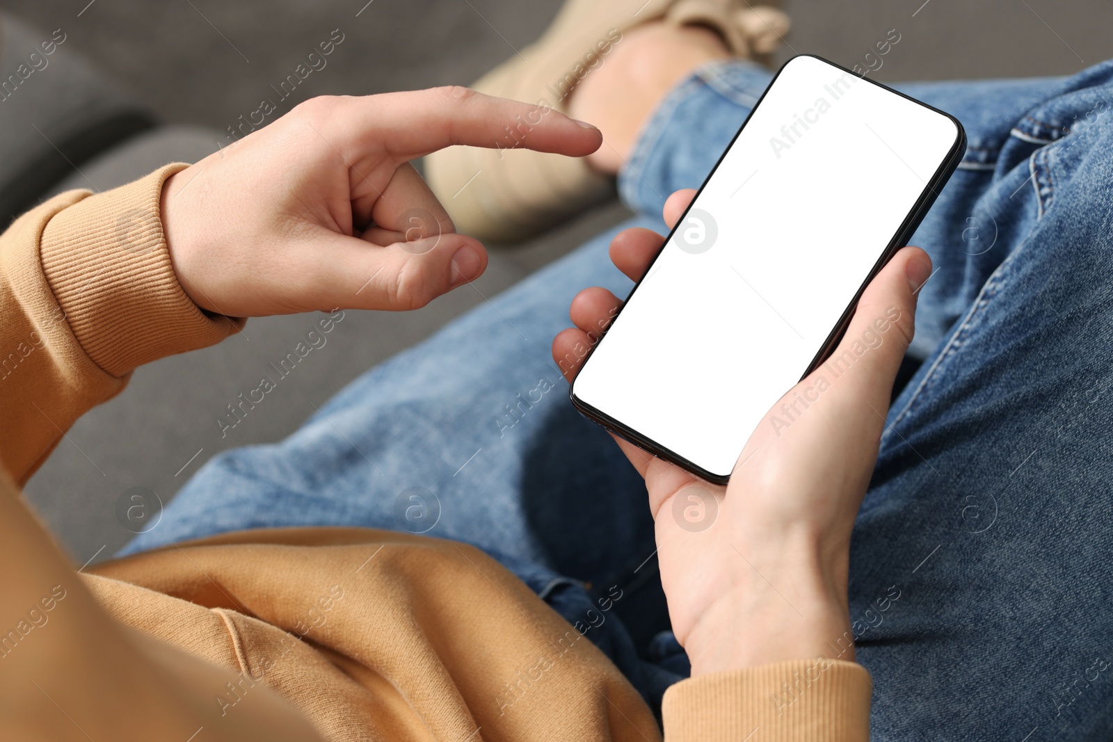 Photo of Man using smartphone with blank screen indoors, closeup. Mockup for design