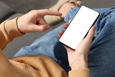 Photo of Man using smartphone with blank screen indoors, closeup. Mockup for design