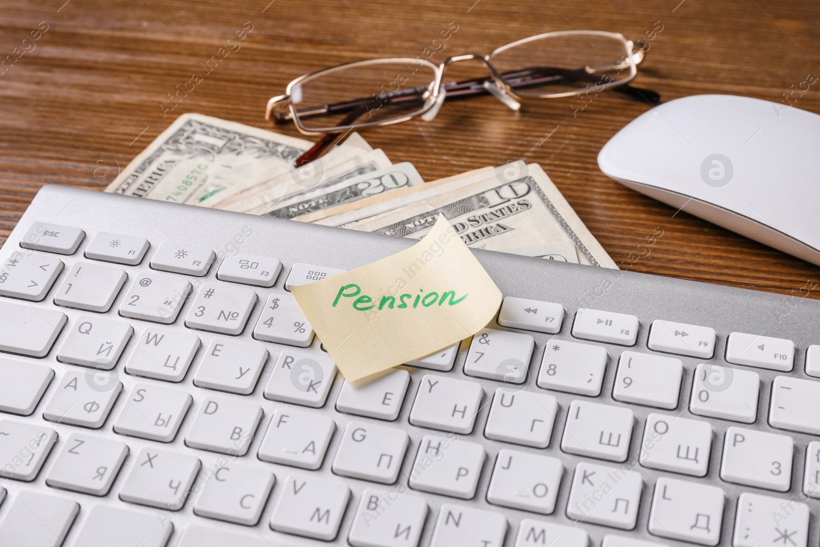 Photo of Paper note with word PENSION, keyboard and money on table