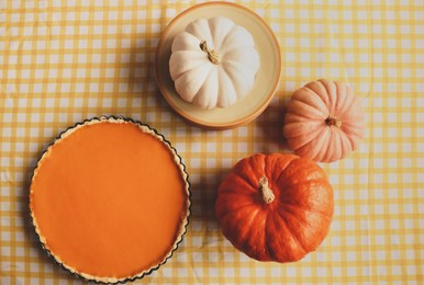 Delicious homemade pie and pumpkins on table, flat lay