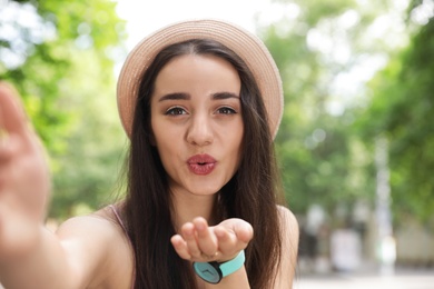 Photo of Beautiful young woman taking selfie outdoors on sunny day